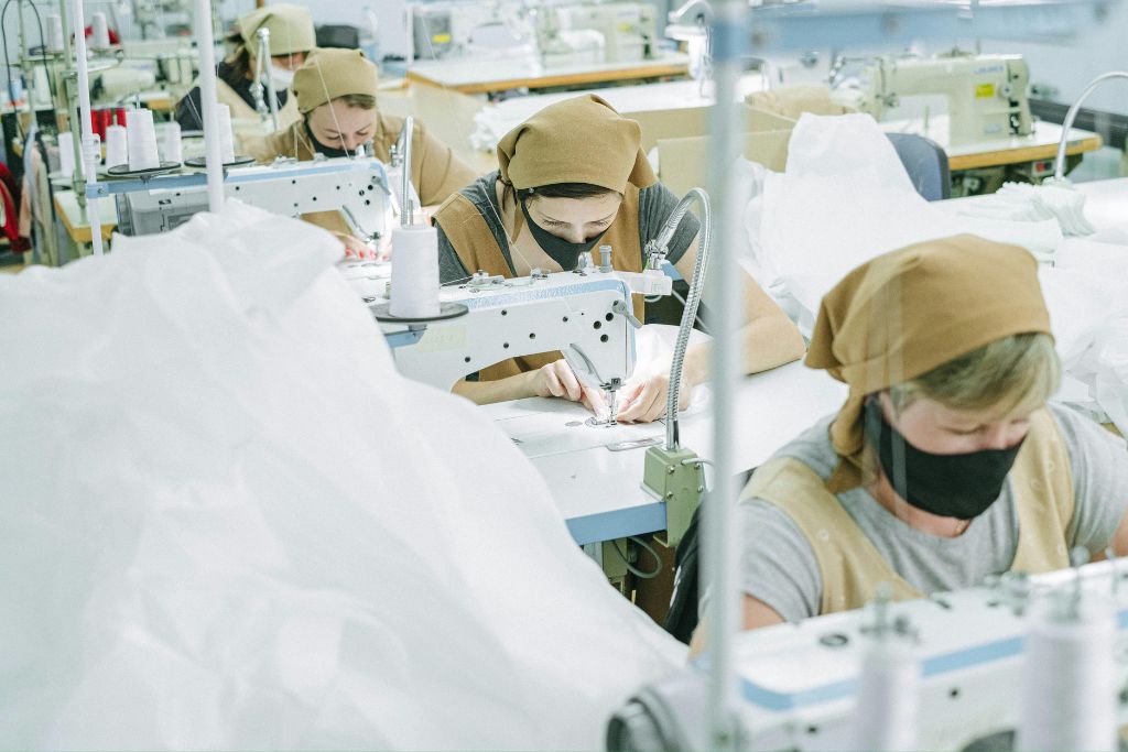 Factory workers operating sewing machines in a Boise industrial setting, reflecting workplace compliance with Idaho drug testing regulations.